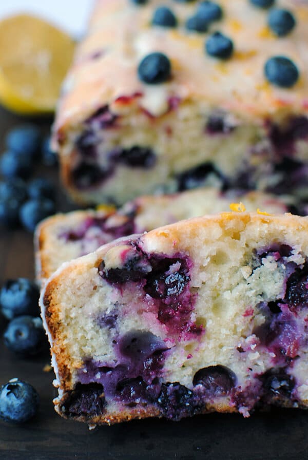 Lemon Blueberry Bread with Lemon Glaze sliced on cutting board