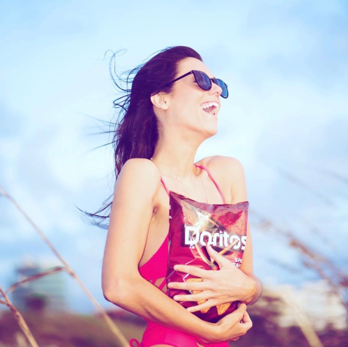 Liz Plank Engagement Shoot with a Bag of Doritos - holding bag and laughing