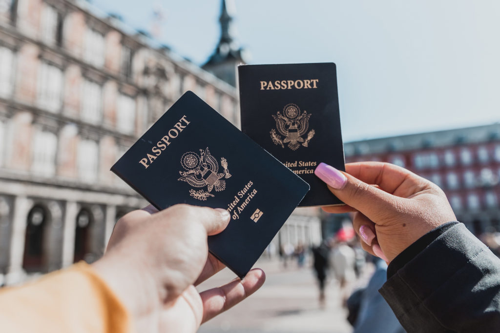 how to take your own passport photos - women holding passports