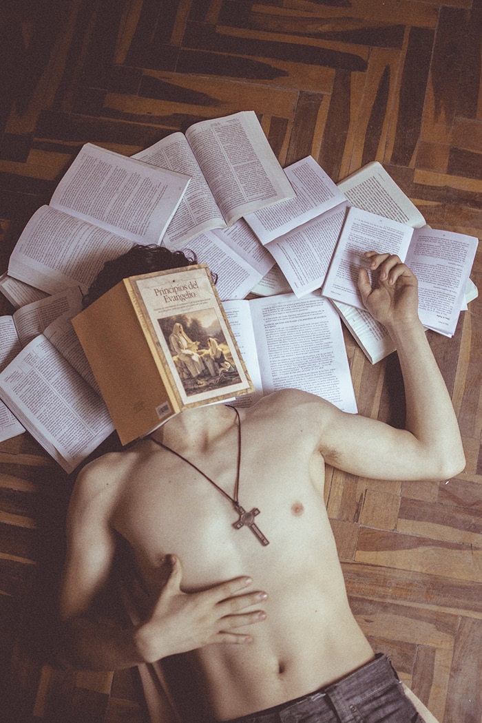 Reading List - shirtless man with book on his face