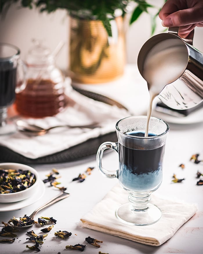 Butterfly Pea Flower Tea Latte - pouring milk into glass