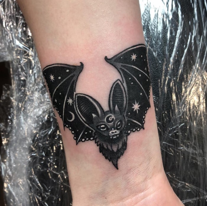 Upside down bat tattoo on the left inner arm