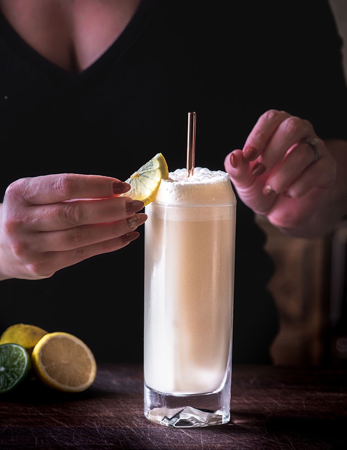 Ramos Gin Fizz - bartender placing lemon wedge