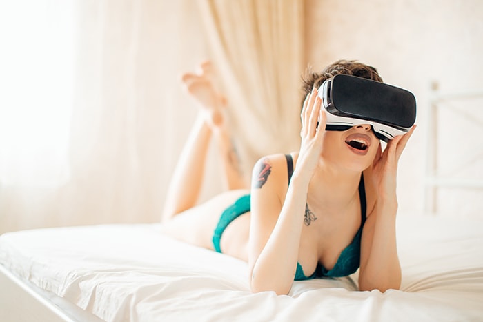 Sex and Porn in the Metaverse - Woman In Bed Wearing VR Goggles