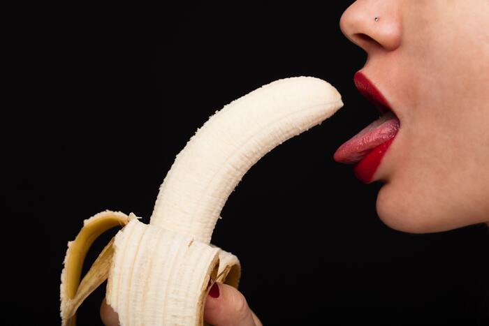 Flavored Condoms - woman licking banana