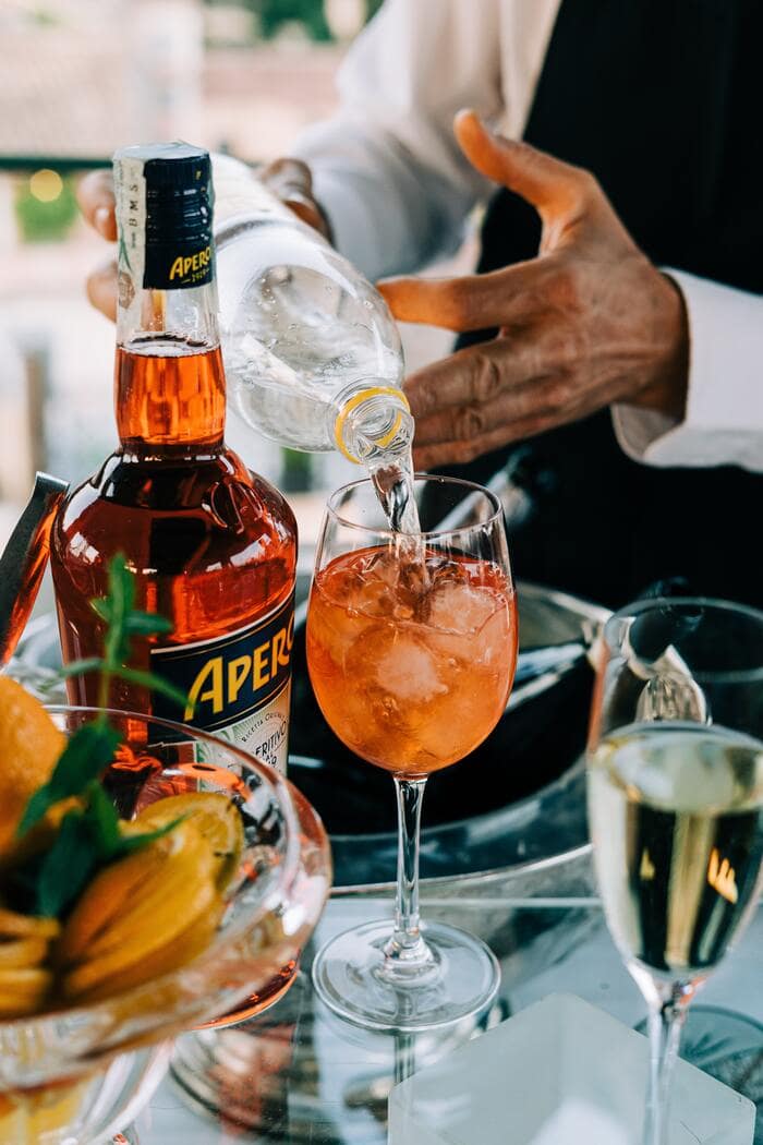 Aperol vs Campari - pouring Aperol on a glass