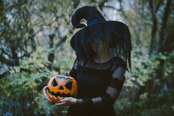 Halloween Puns - witch holding a jack-o'-lantern