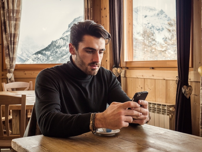 Sexy Texts - man at coffeeshop holding phone