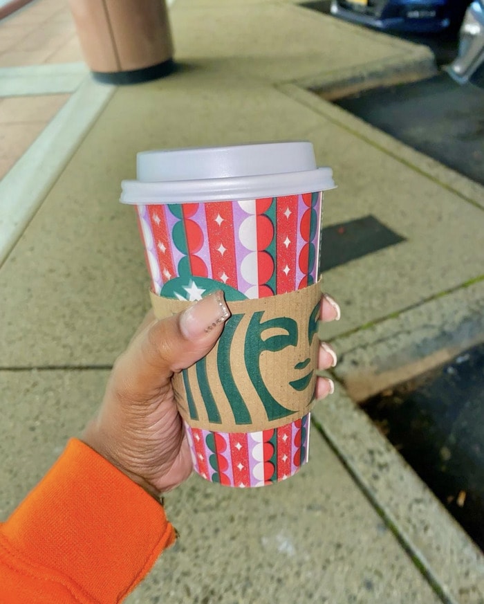 Starbucks Hot Chocolate - person holding festive cup