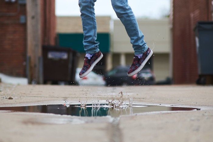 Physically Active Self Care Ideas - woman jumping in puddle