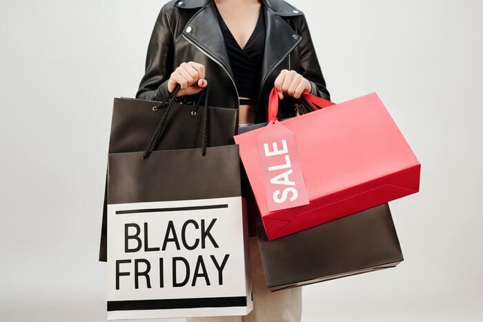 How to Stop Spending Money - person holding sale bags