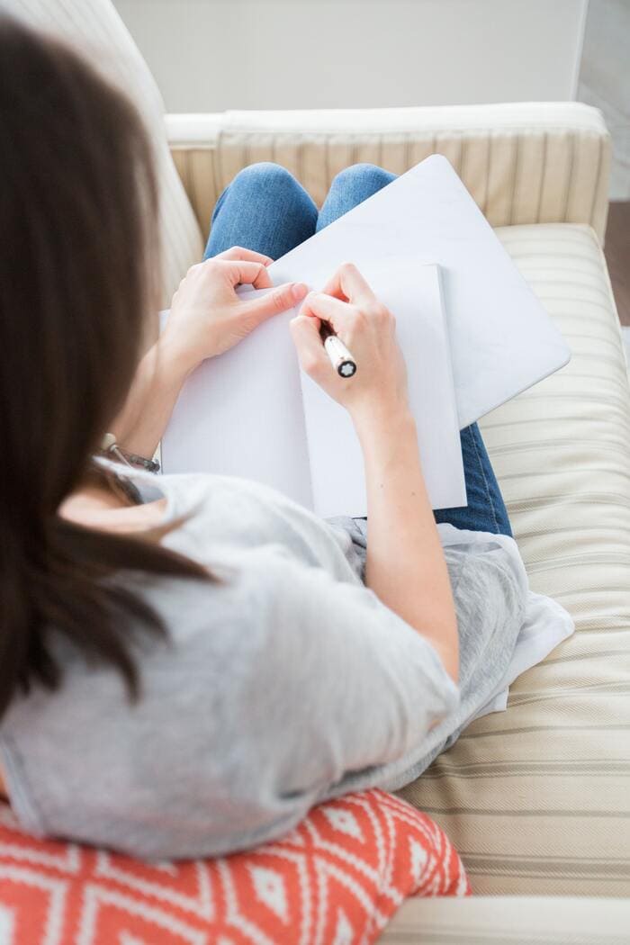 How to Stop Spending Money - woman writing goals