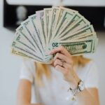 How to Stop Spending Money - woman holding cash