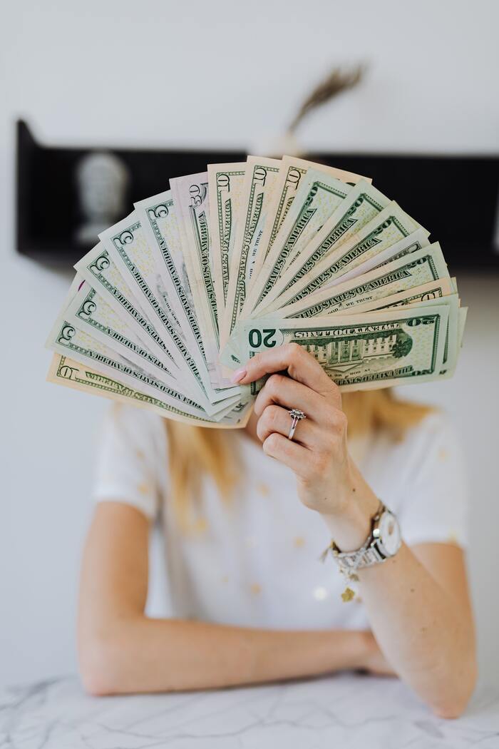 How to Stop Spending Money - woman holding cash