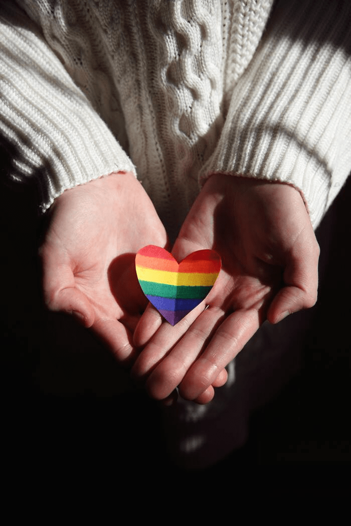 Polycule meaning- hands holding rainbow heart