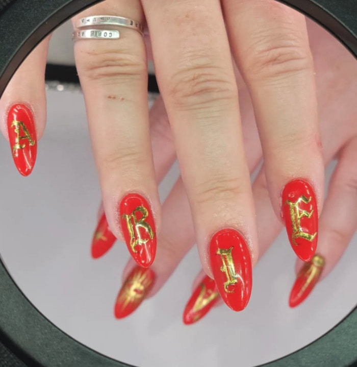 Aries Nails - Red and gold lettering