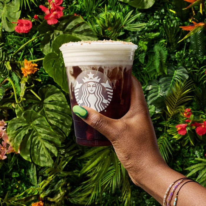 Starbucks White Chocolate Macadamia Cream Cold Brew Review - hand holding with tropical background