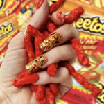 Cheetos Facts - holding flamin hot cheetos