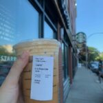 Starbucks Iced Pumpkin Chai Tea Latte Review - drink in front of Starbucks sign