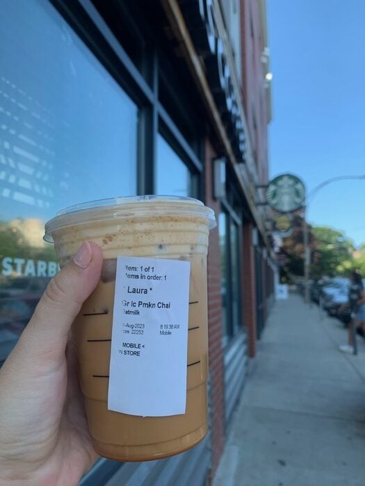 Starbucks Iced Pumpkin Chai Tea Latte Review - drink in front of Starbucks sign