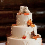 fall wedding cakes - two owls on a white cake with colorful frosted leaves