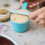 Baking Tips for Beginners - baker measuring ingredients in a measuring cup