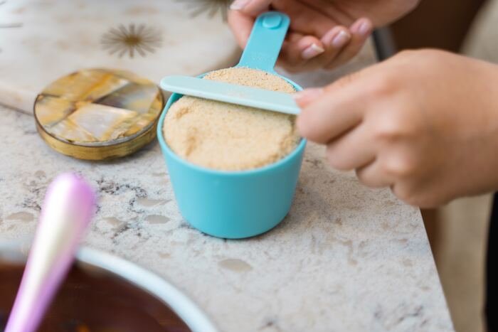 Baking Tips for Beginners - baker measuring ingredients in a measuring cup